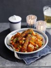 Bohneneintopf mit Süßkartoffeln und Wurst auf weißem Teller mit Gabel — Stockfoto