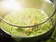 Pea soup in saucepan — Stock Photo