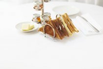Elevated view of toasts in a toast rack served with butter and various jars of jam — Stock Photo