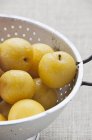 Yellow plums in colander — Stock Photo