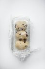 Primo piano vista dall'alto dei pezzi di pasta cruda con frutta in teglia ricoperta di pellicola trasparente — Foto stock
