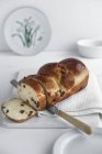 Крупним планом нарізаний фруктовий хліб на білій дошці з кухонним рушником — стокове фото