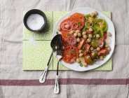 Ensalada de garbanzos y tomate con aros de cebolla - foto de stock