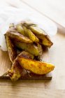 Roasted potato wedges in paper — Stock Photo