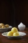 Bolinhos de batata com ingredientes em pratos brancos sobre mesa — Fotografia de Stock