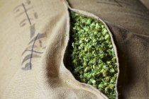 Closeup view of beer hops in an opened jute sack — Stock Photo