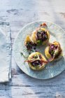 Onion and anchovy tartlets on plate — Stock Photo