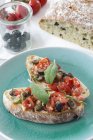 Bruschetta mit Tomaten, Oliven und Salbei auf blauem Teller — Stockfoto