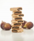 Une pile de rouleaux de figue avec des figues fraîches en arrière-plan — Photo de stock