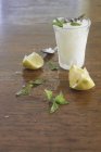 Nahaufnahme von Zitronengranita mit Zitronen und frischer Minze auf einer Holzoberfläche — Stockfoto