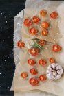 Tomates cerises cuites au four avec sel et ail sur papier support — Photo de stock