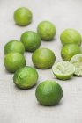 Citrons verts frais avec moitiés pressées — Photo de stock