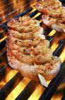 Closeup view of spicy prawn skewers on flaming grill — Stock Photo