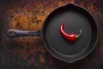 Red chilli pepper in iron pan — Stock Photo