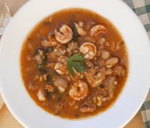Prawn soup with sausage and beans on white plate — Stock Photo