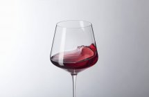 Vin rouge swilling dans un verre — Photo de stock