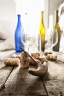 Primo piano vista di un cavatappi con tappi, bottiglie di vino vuote e bicchieri — Foto stock