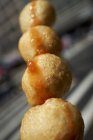 Closeup view of grilled fish balls on a wooden skewer — Stock Photo