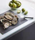 Fresh oysters with limes — Stock Photo