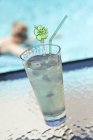 Closeup view of lime drink with ice cubes by a pool — Stock Photo