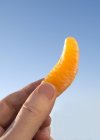 Mano che tiene un segmento di mandarino — Foto stock