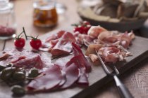 Cold cuts on wooden chopping board — Stock Photo