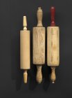 Top view of three wooden rolling pins on black surface — Stock Photo