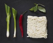 Ingredients for udon noodle soup on black surface — Stock Photo