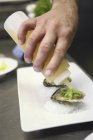 Man drizzling Oysters with juice — Stock Photo