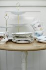 Vintage crockery including plates, cups and a cake stand on a table — Stock Photo