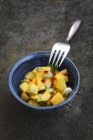 Mango relish in black bowl with fork — Stock Photo