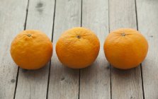 Ripe mandarins on a wooden surface — Stock Photo
