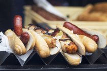 Hot dogs and grilled chicken skewers — Stock Photo