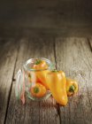 Pimientos naranjas frescos con frasco de conservación - foto de stock