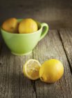 Limoni freschi e metà con ciotola — Foto stock