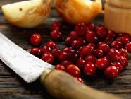 Cranberries with onions and old knife — Stock Photo