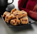 Nahaufnahme von Cranberry Fudge Stücke auf schwarzem quadratischen Teller — Stockfoto