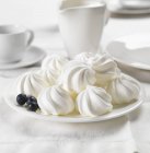 Meringues and blueberries on plate — Stock Photo