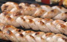 Sausages braids on grill — Stock Photo