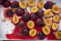 Oven roasted damsons with rosemary on a baking tray — Stock Photo