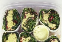 Vegetarische Wraps gefüllt mit rohem Gemüse in Plastikbehältern — Stockfoto