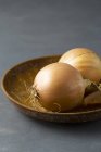 Cebollas sobre plato de madera - foto de stock