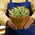 Man holding basket of green beans — Stock Photo