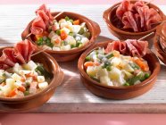 Vegetable salads with raw ham in bowls — Stock Photo