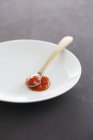 Ketchup fatto in casa su piastra bianca con cucchiaio — Foto stock