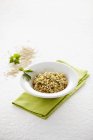 Elevated view of wholemeal Risotto with lovage in a bowl on a green napkin — Stock Photo