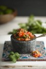 Salsa de tomate com coentro fresco em vaso de pedra sobre mesa — Fotografia de Stock