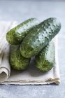 Fresh cucumbers on linen cloth — Stock Photo