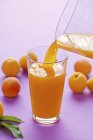 Наливают абрикосовый сок — стоковое фото