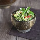 Tabbouleh with green chickpeas in wooden bowl over towel — Stock Photo